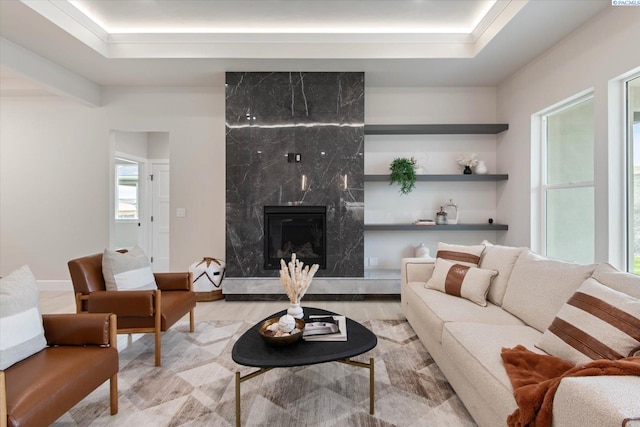 living room featuring a tray ceiling and a fireplace