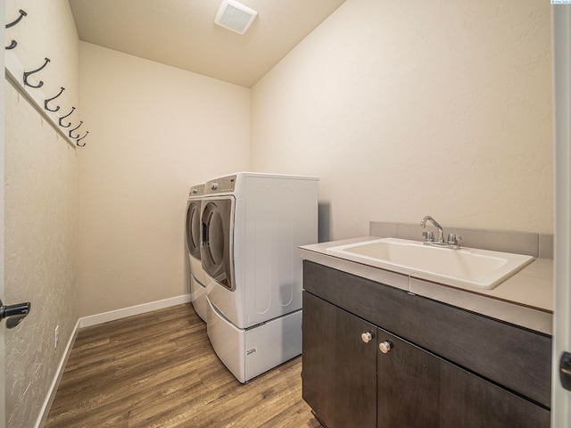 5593 S Lyle Pl, Kennewick, WA 99337 - laundry room with washer and dryer, light wood-style flooring, a sink, and baseboards