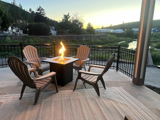 balcony at dusk featuring a fire pit