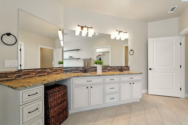 full bath with tile patterned floors, double vanity, backsplash, a sink, and visible vents