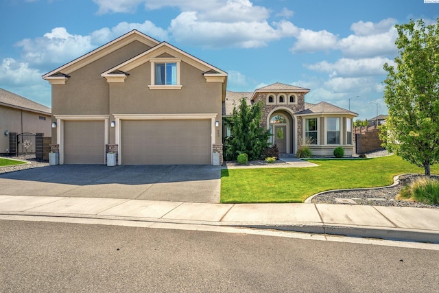 mediterranean / spanish-style house featuring stucco siding, driveway, stone siding, a front lawn, and an attached garage