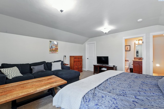 bedroom with carpet flooring, vaulted ceiling, and connected bathroom