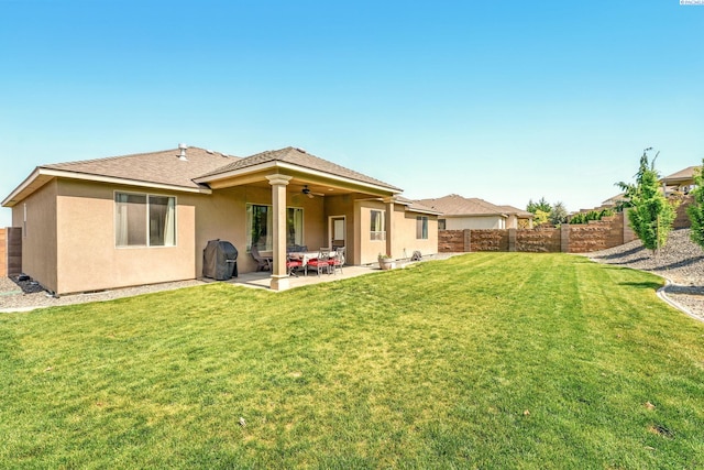 rear view of property with ceiling fan, stucco siding, a fenced backyard, and a patio area