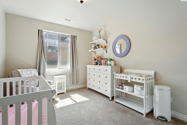bedroom featuring a crib, visible vents, carpet, and baseboards