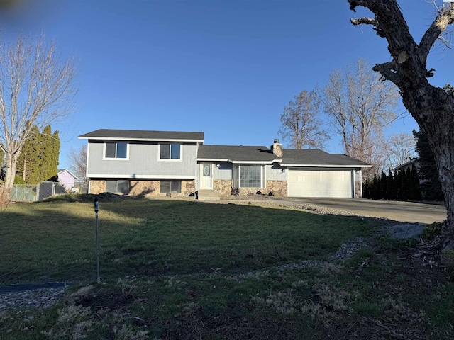 split level home with a garage and a front lawn