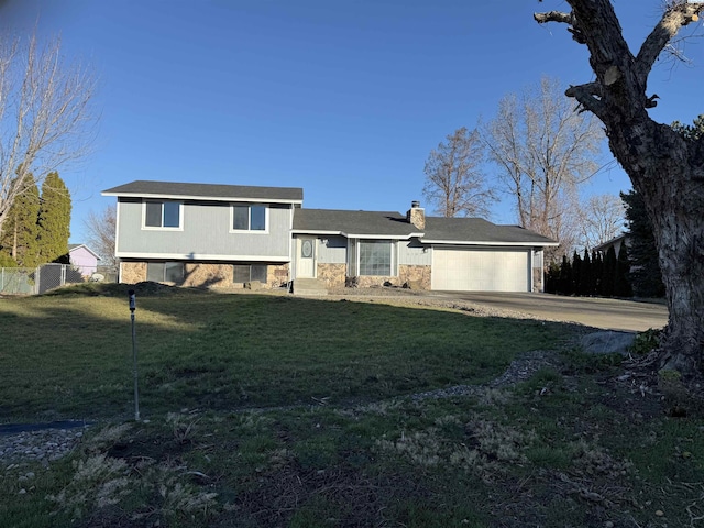 split level home with a garage and a front lawn