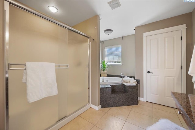 full bath featuring visible vents, a stall shower, baseboards, tile patterned floors, and a garden tub