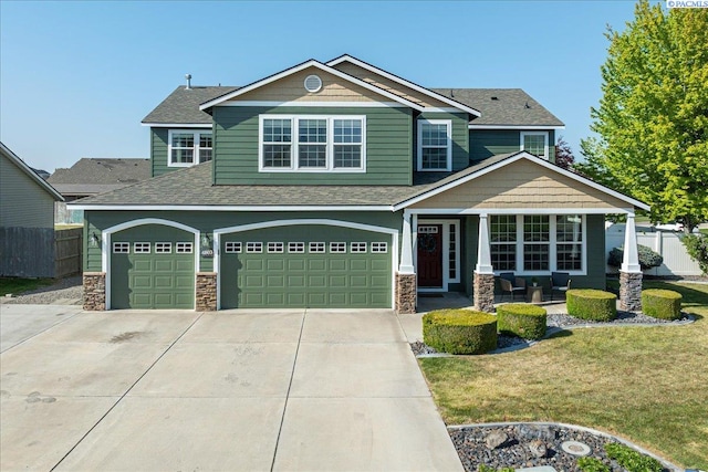 craftsman inspired home featuring fence, a garage, and stone siding