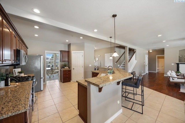 kitchen featuring light tile patterned floors, a breakfast bar, recessed lighting, and appliances with stainless steel finishes