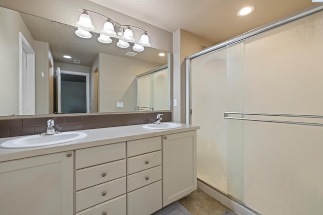 bathroom with tasteful backsplash, vanity, and walk in shower