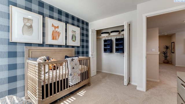 carpeted bedroom featuring a crib and a closet