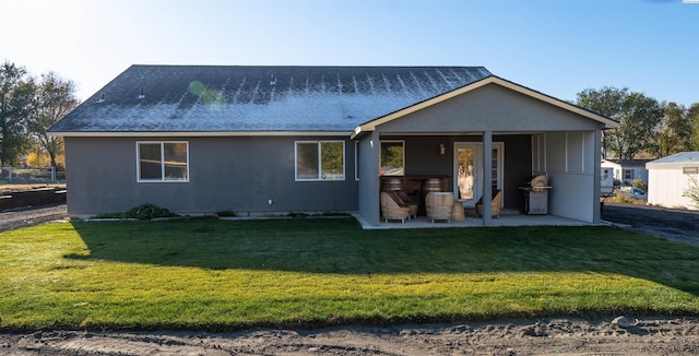 back of property with a yard and a patio