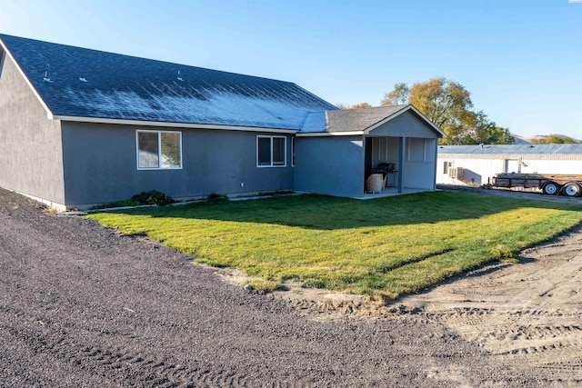 back of house with a patio area and a lawn