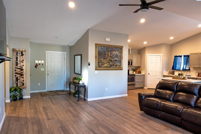 living room featuring hardwood / wood-style flooring, lofted ceiling, and ceiling fan