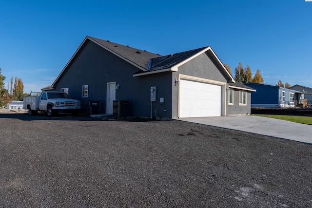 view of side of home featuring a garage and central AC unit