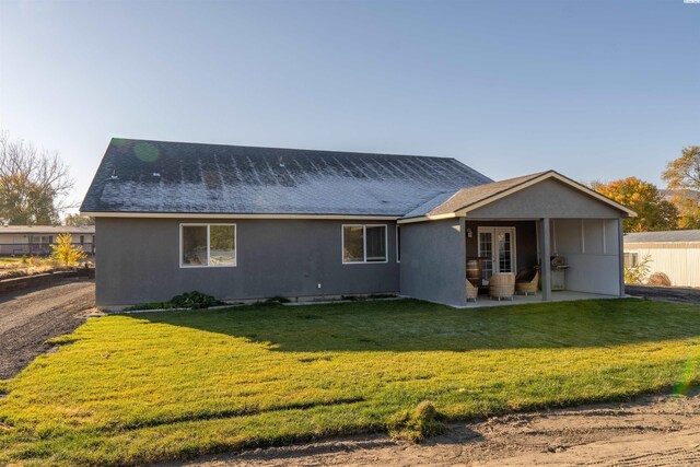 back of house with a yard and a patio