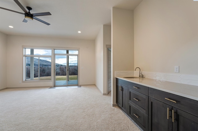 interior space with light carpet, a mountain view, a sink, and recessed lighting