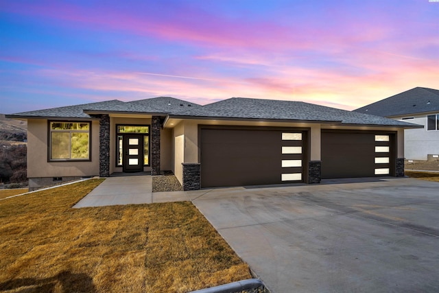 prairie-style house with a garage and a lawn