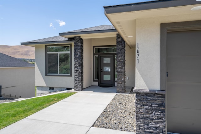 entrance to property with crawl space, a shingled roof, and stucco siding