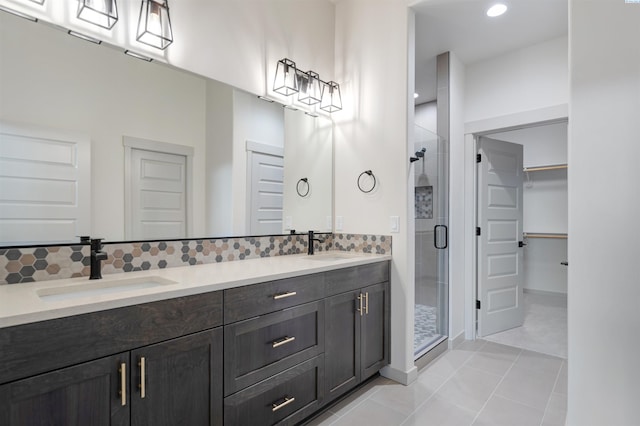 full bathroom with a spacious closet, tasteful backsplash, and a sink