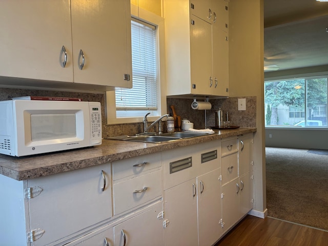 1320 NE Harvey Rd, Pullman, WA 99163 - kitchen with white microwave, a sink, tasteful backsplash, a ceiling fan, and dark wood-style floors