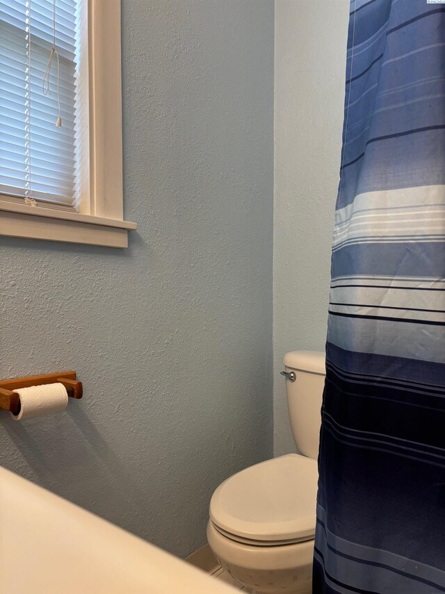 1320 NE Harvey Rd, Pullman, WA 99163 - bathroom with toilet, a textured wall, and a shower with shower curtain