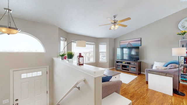 living room with hardwood / wood-style flooring, vaulted ceiling, and ceiling fan