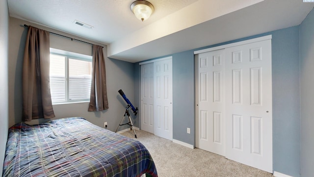 carpeted bedroom featuring multiple closets