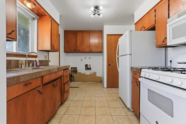 kitchen with light tile patterned flooring, sink, and white appliances