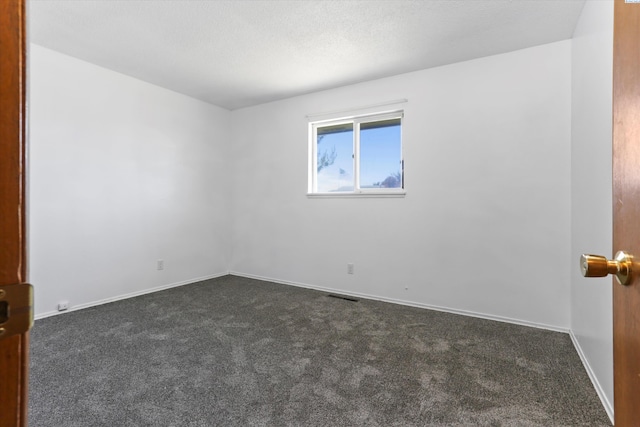 carpeted spare room featuring a textured ceiling