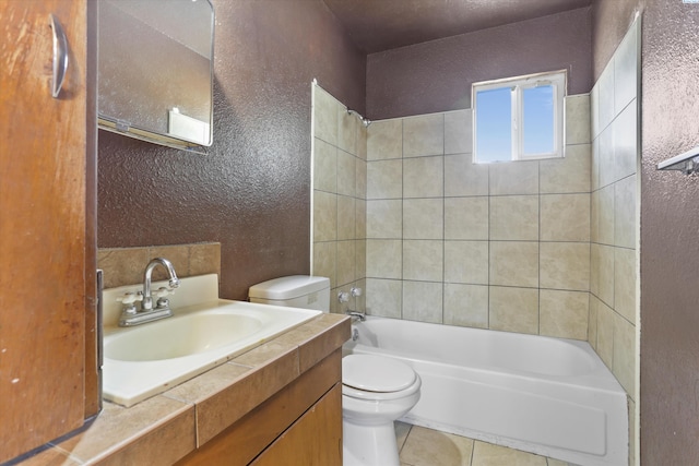 full bathroom featuring vanity, tile patterned flooring, tiled shower / bath combo, and toilet