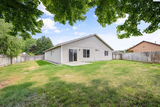 rear view of house featuring a yard, a patio, and a fenced backyard
