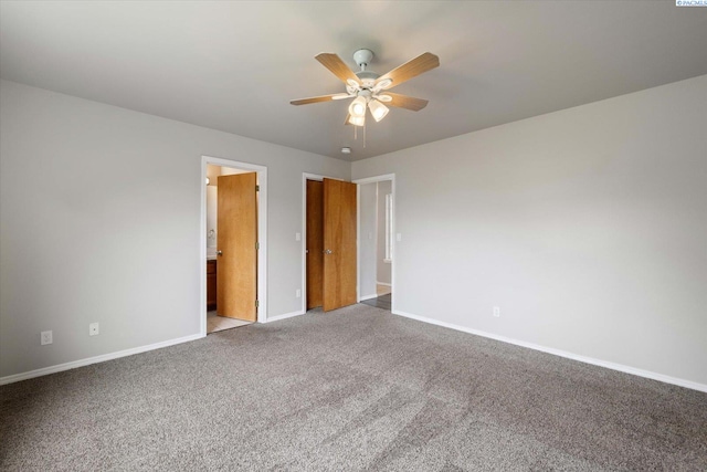 empty room with carpet floors, a ceiling fan, and baseboards