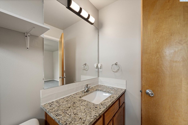 half bathroom featuring vanity and toilet