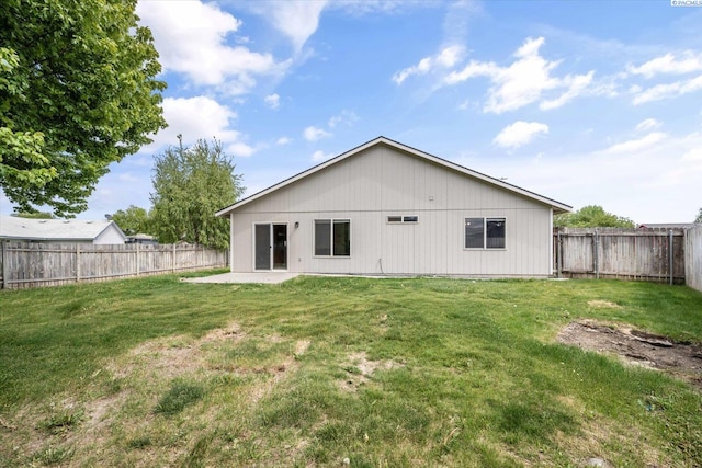 rear view of property featuring a fenced backyard, a patio area, and a yard