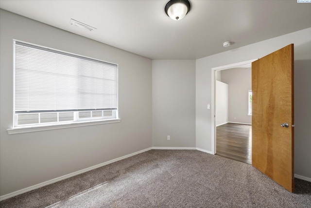 unfurnished room featuring carpet flooring, baseboards, and visible vents