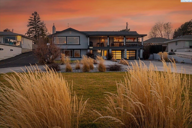 rear view of property featuring a balcony and a lawn