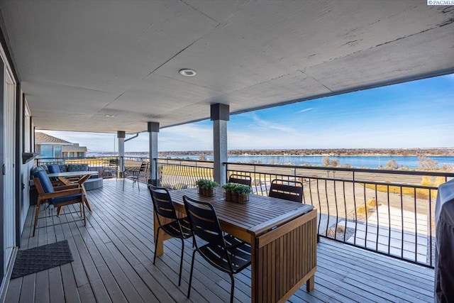 wooden terrace featuring a water view and outdoor dining space