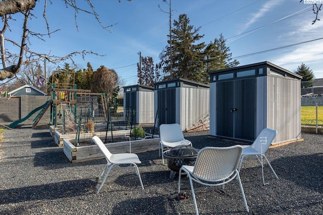 view of yard featuring a shed, fence, a playground, and an outdoor structure