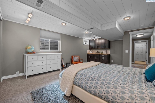 carpeted bedroom featuring visible vents, baseboards, and crown molding