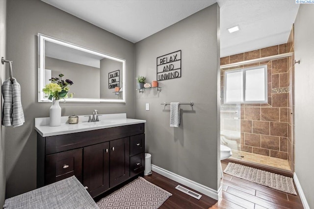 bathroom featuring visible vents, a stall shower, wood finished floors, and toilet