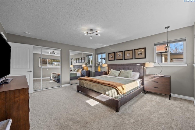 bedroom with carpet floors, multiple windows, and multiple closets