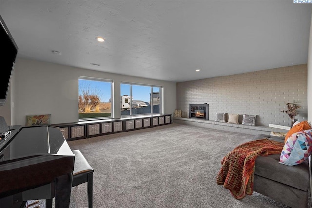 home theater with visible vents, brick wall, carpet, a fireplace, and recessed lighting