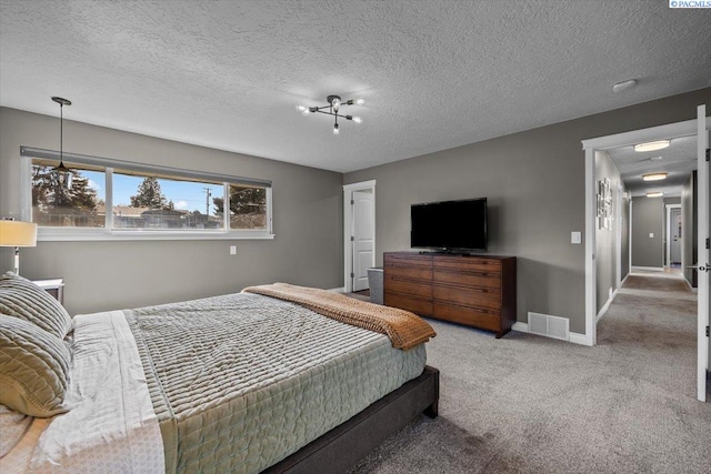 carpeted bedroom with baseboards, visible vents, and a textured ceiling