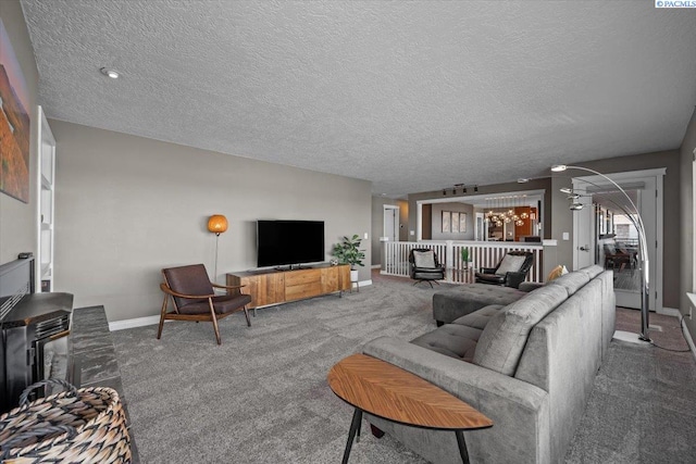 carpeted living area with a textured ceiling and baseboards