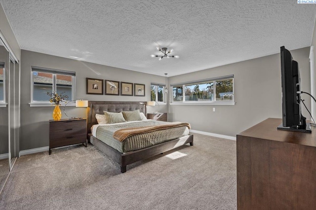 carpeted bedroom featuring baseboards and a textured ceiling