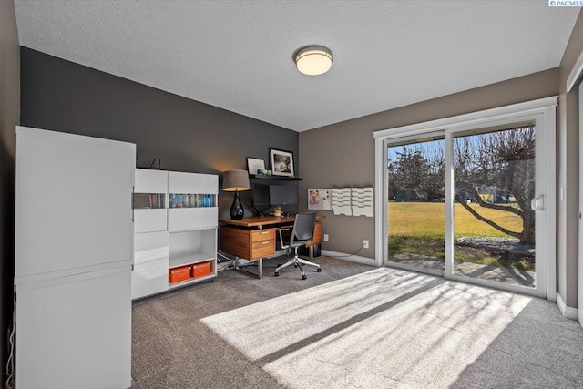 home office featuring a textured ceiling, carpet flooring, and baseboards