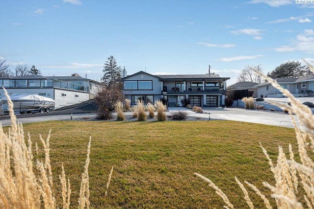 view of front of property featuring driveway, a front lawn, and a patio