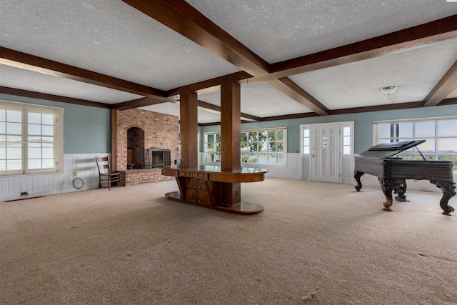 living room featuring a textured ceiling, beamed ceiling, and carpet flooring