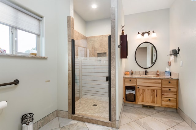 bathroom with a shower with door, vanity, and tile patterned flooring